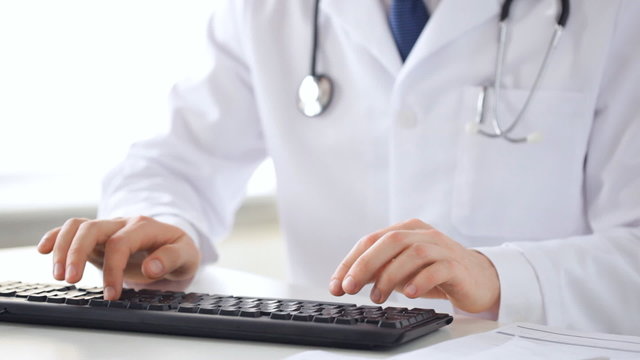 male doctor hands typing on keyboard