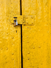 Padlock on an old yellow door