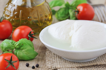 Fresh balls of mozzarella cheese with tomatoes and basil
