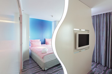 Hotelzimmer mit Bett, Fernseher und Trennwand