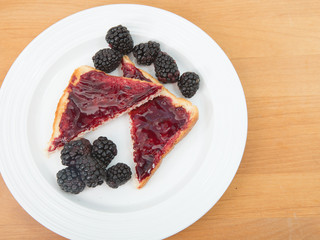 Plate of toast with jam and fresh blackberries