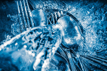 Metallic silverware washed under a water stream - 51695669