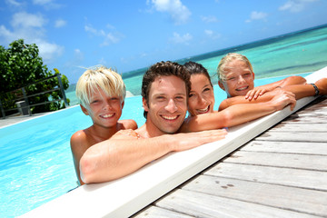 Family of four bathing in swimming pool
