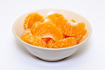 peeled mandarin orange in a bowl on white background