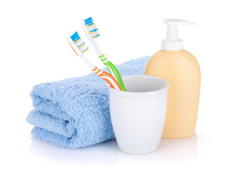 Two colorful toothbrushes, liquid soap and towel