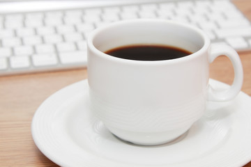 cup of coffee in front of keyboard