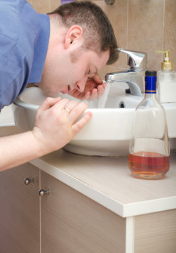 Man with hangover washing up