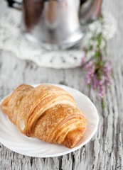 Croissant, teapot and branch of heather