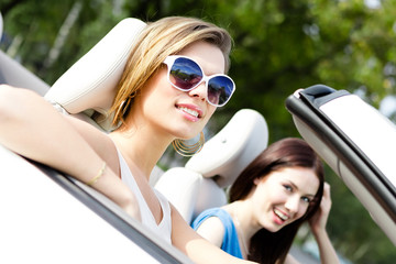 Two girls ride the cabriolet