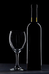 Wine glass and bottle on black background