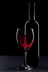 Wine glass and bottle on black background