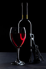 Wine glass and bottle on black background