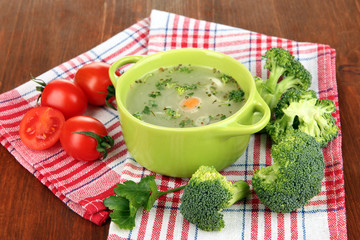 Diet soup with vegetables in pan on wooden table close-up
