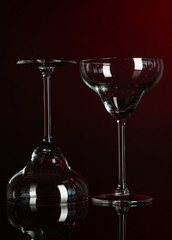 Two glasses on dark red background