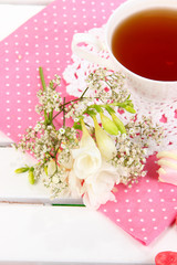 Beautiful composition with cup of tea and flowers
