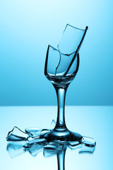 Broken wineglass on blue background