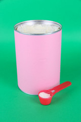 Powdered milk for baby on green background.