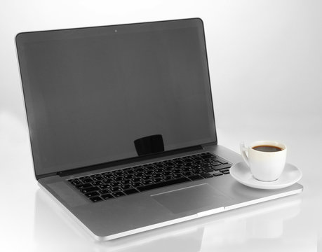 White laptop with cup of coffee isolated on white