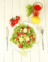 Caesar salad on white plate, on color wooden background