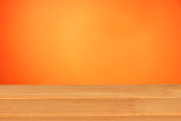 Wooden table on orange background