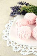 Marshmallows on plate on light background