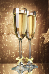 Two glasses of champagne on bright background with lights