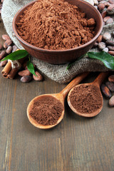 Cocoa powder and cocoa beans  on wooden background