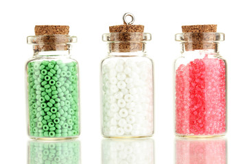 Little bottles full with colorful beads isolated on white