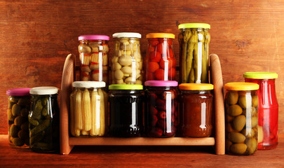 Different conservations on shelves on wooden background
