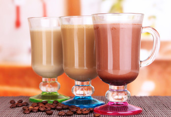 Layered coffee in glass on table on bright background
