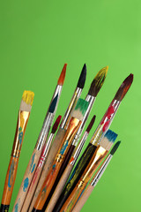 Obraz premium Many brush in paint on green background