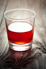 The glass with alcohol costs on a wooden table