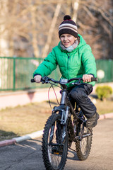 Fototapeta na wymiar Nice little boy goes by him bicycle