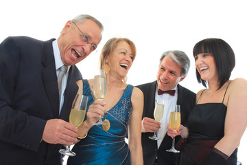 Lachende Leute in Abendgarderobe mit Glas Alkohol