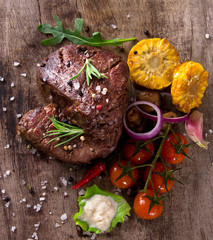 Delicious beef steaks on wooden table