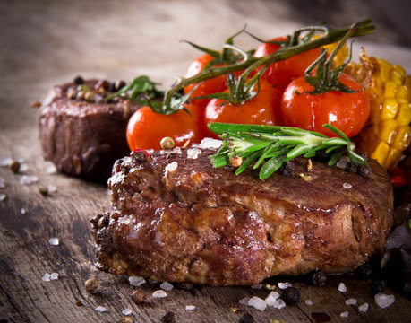 Delicious beef steaks on wooden table