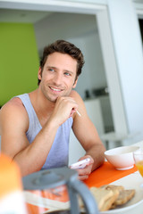 Man using smartphone while having breakfast