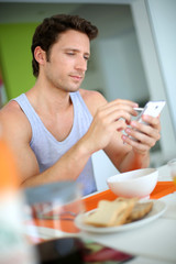 Man using smartphone while having breakfast