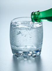 Mineral water pouring into glass