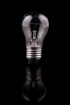 Light bulb on black background, reflection