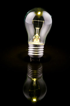 Light bulb on black background, reflection