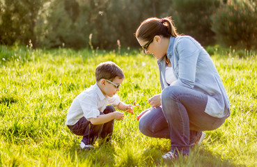 Mother and son picking flowers in a field