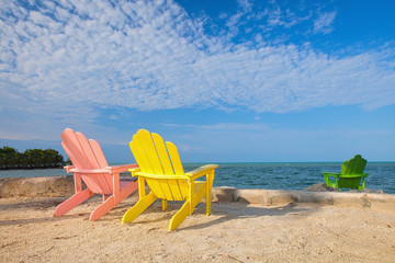 Summer scene with colorful lounge chairs on a tropical beach