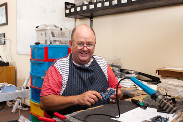 happy senior man in workshop