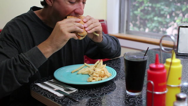 Unhealthy Eating, man eating fast food hamburger