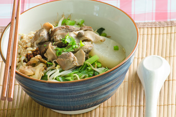 A bowl of Thai style beef noodle with spoon and chopstick.