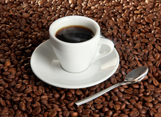 Cup of coffee on coffee beans background