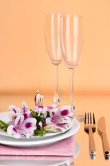 Obraz na płótnie Canvas Festive table setting with flowers on peachy background