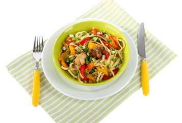 Noodles with vegetables on plate on napkin isolated on white