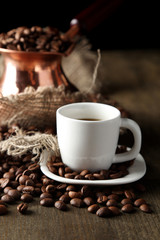 Cup of coffee and pot on wooden background